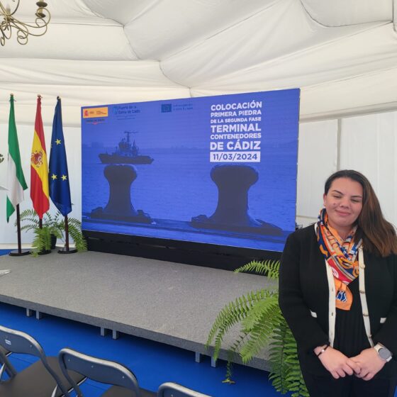 Ana Ginesta, posa junto al stand en el acto de la colocación de la primera piedra de la nueva terminal de contenedores